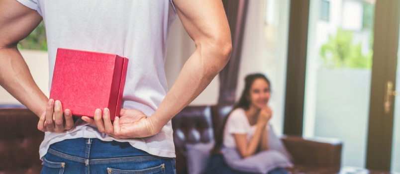 ¿Cuáles son algunos regalos románticos que has recibido? Chico con un regalo detrás de él para sorprender a su novia que espera